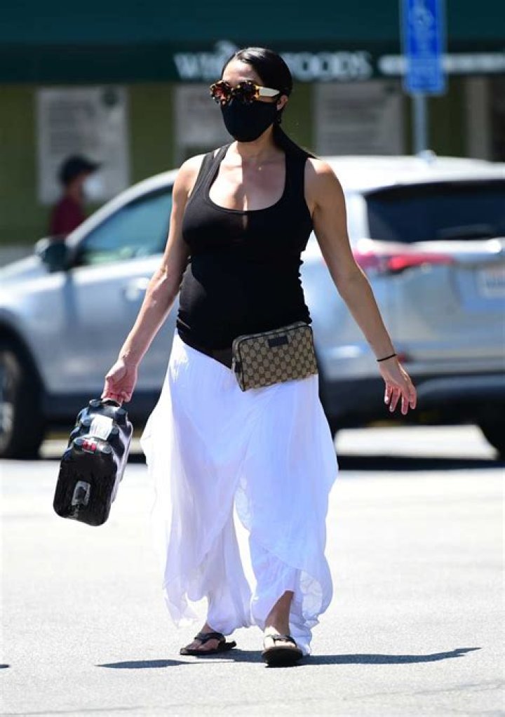 Nikki Bella Cradles Her Growing Baby Bump In Velvet Pink Dress & Snakeskin Boots